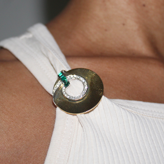 Close-up of a decorative brooch on a white garment