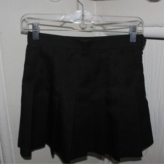 Black shorts on a clear hanger against a white wall