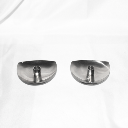 Two silver candle holders on a white background