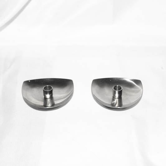 Two silver candle holders on a white background