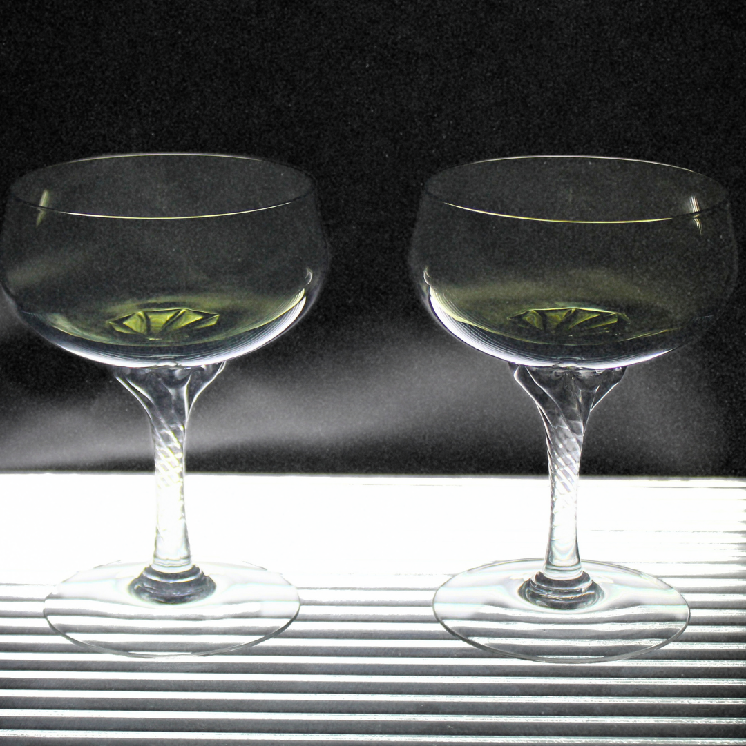 Two clear glasses with a dark background