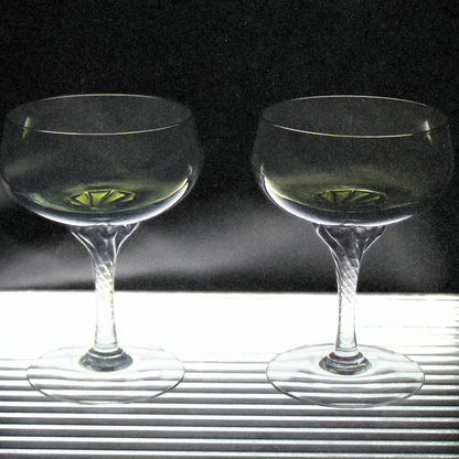 Two clear glasses with a dark background