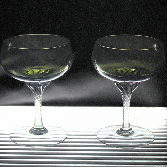 Two clear glasses with a dark background