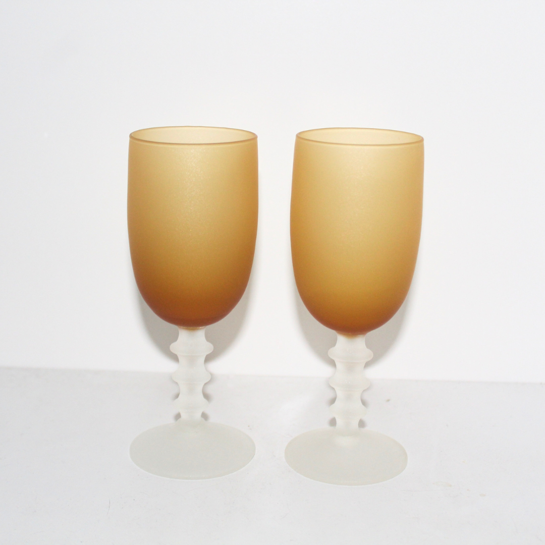 Two gold-colored goblets on a white background