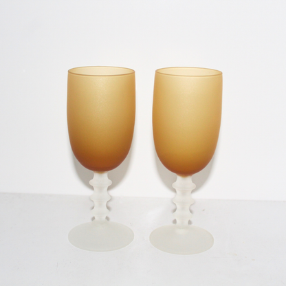 Two gold-colored goblets on a white background